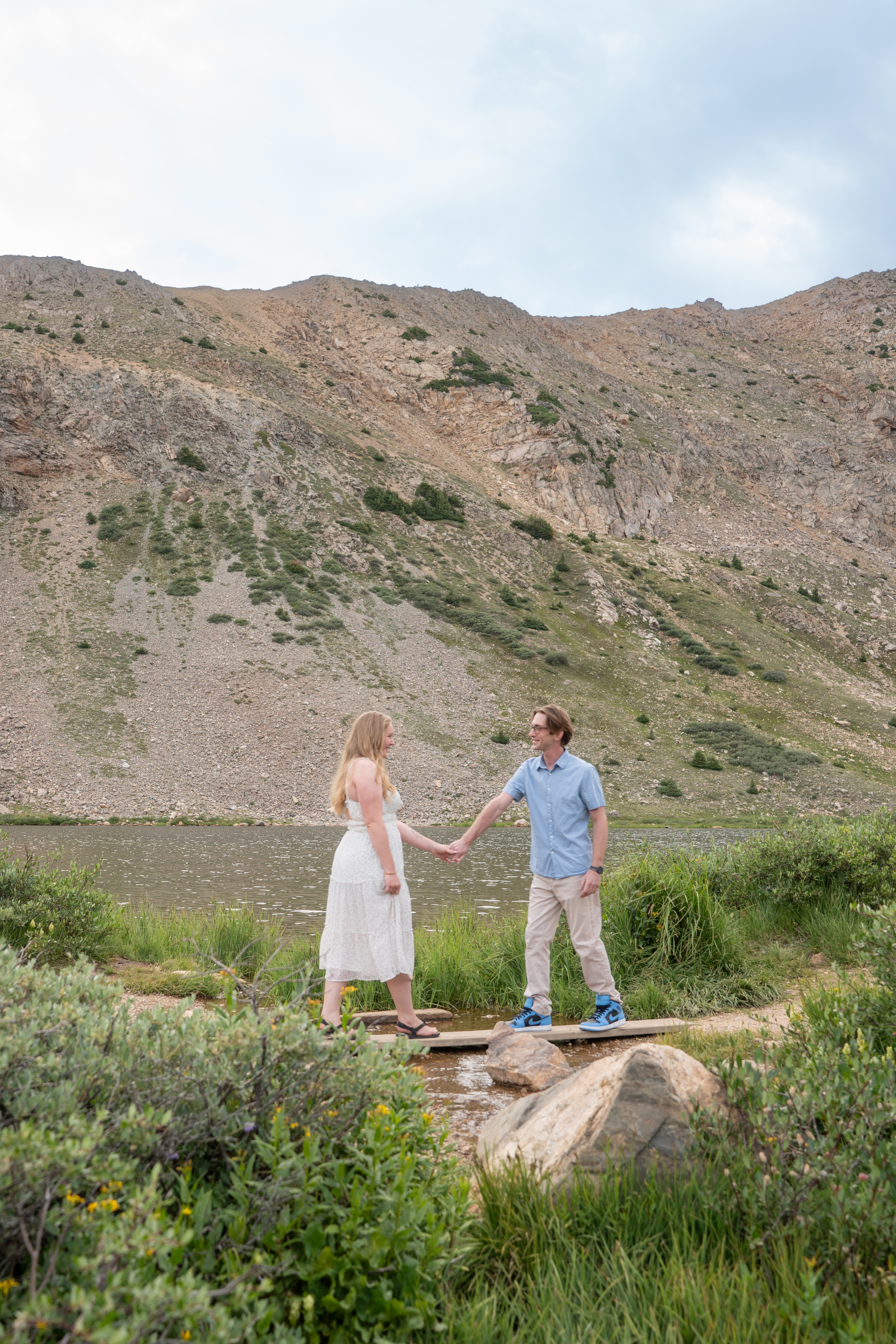 Jerome and Reese holding hands beside an alpine lake
