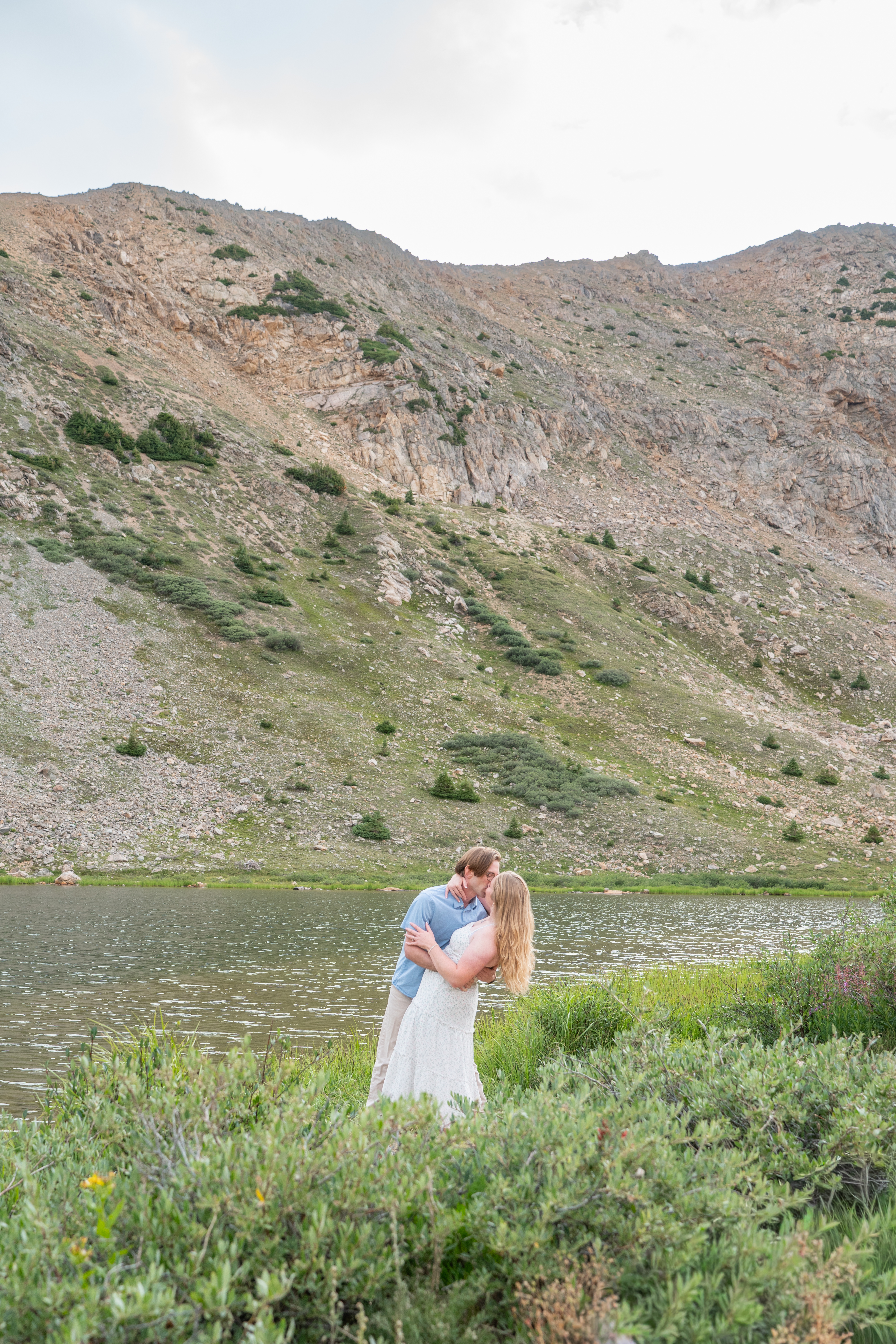Jerome and Reese embracing beside a mountain lake