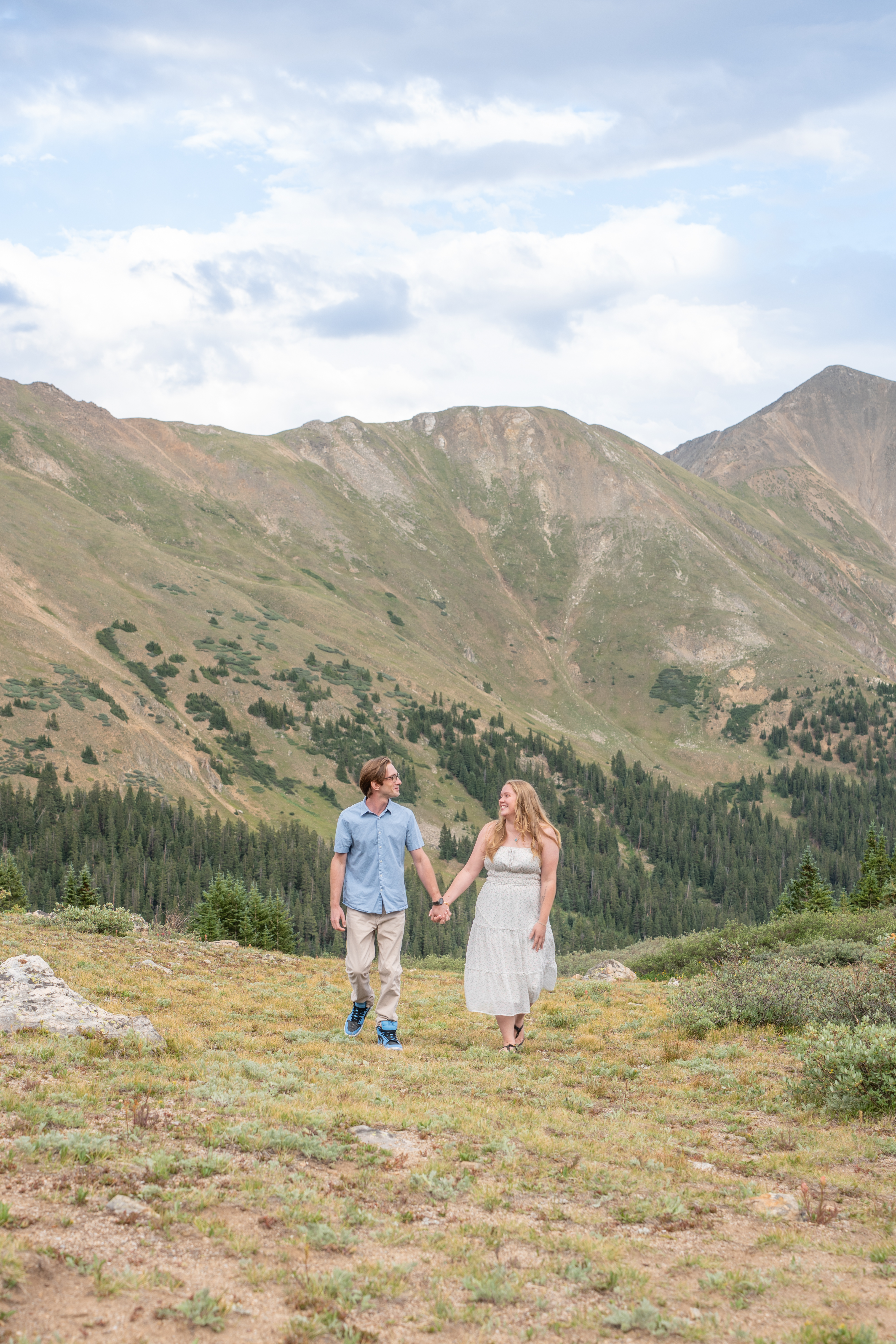 Jerome and Reese walking hand in hand in the Colorado mountains